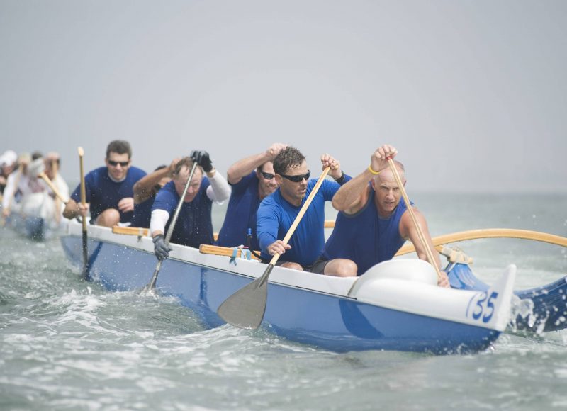 Crew of a racing outrigger canoe on water